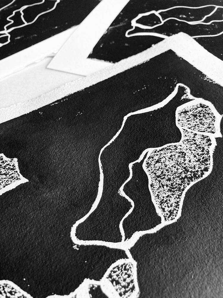 Détail d’une impression en linogravure noire et blanche révélant la texture de l’encre et les lignes gravées