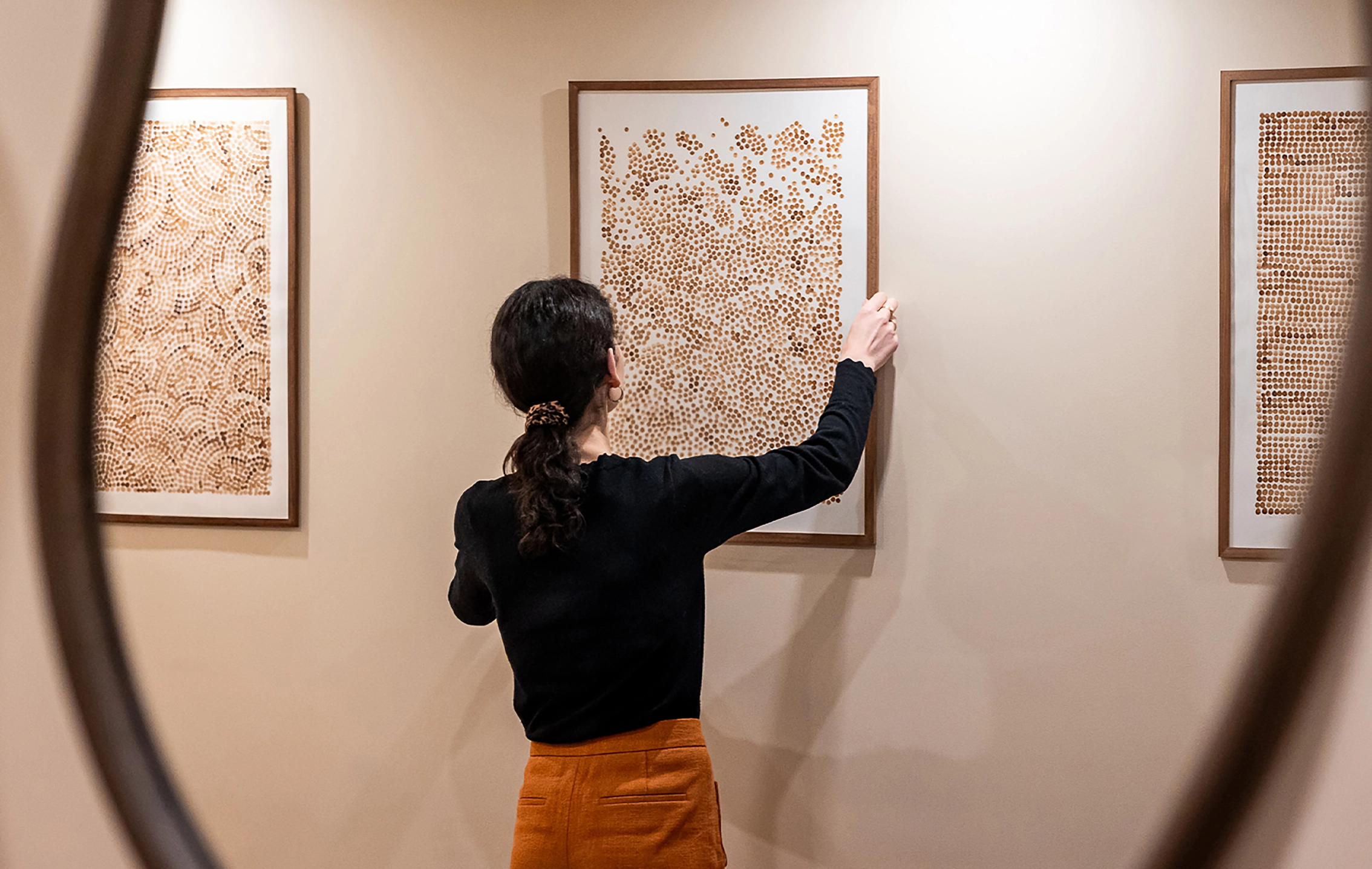 Lola Mathé installant des œuvres contemporaines dans une galerie